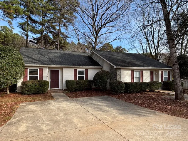 a front view of a house with a yard covered in snow