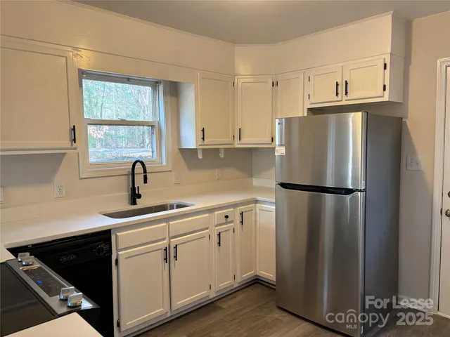 a kitchen with a refrigerator sink and cabinets