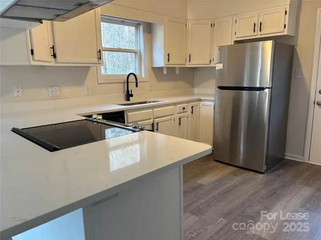 a kitchen with a refrigerator sink and cabinets