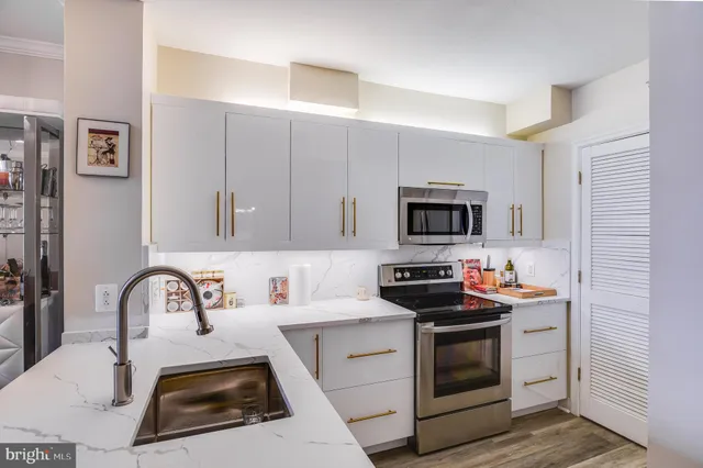 a kitchen with stainless steel appliances a stove sink and cabinets