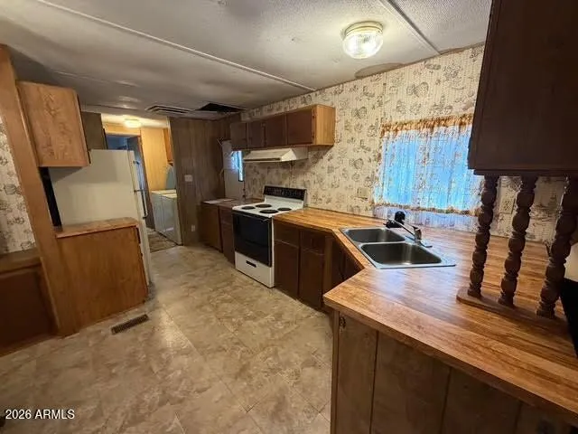 a kitchen with granite countertop a sink a counter top space stainless steel appliances and cabinets