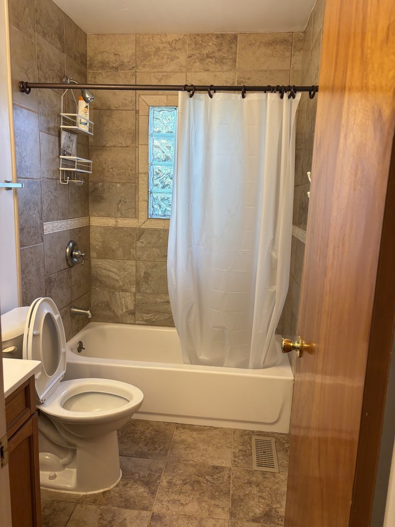 1060 Warwick Lane Elk Grove Village, IL 60007 - Photo 12 of 15 a bathroom with a sink a toilet and a shower