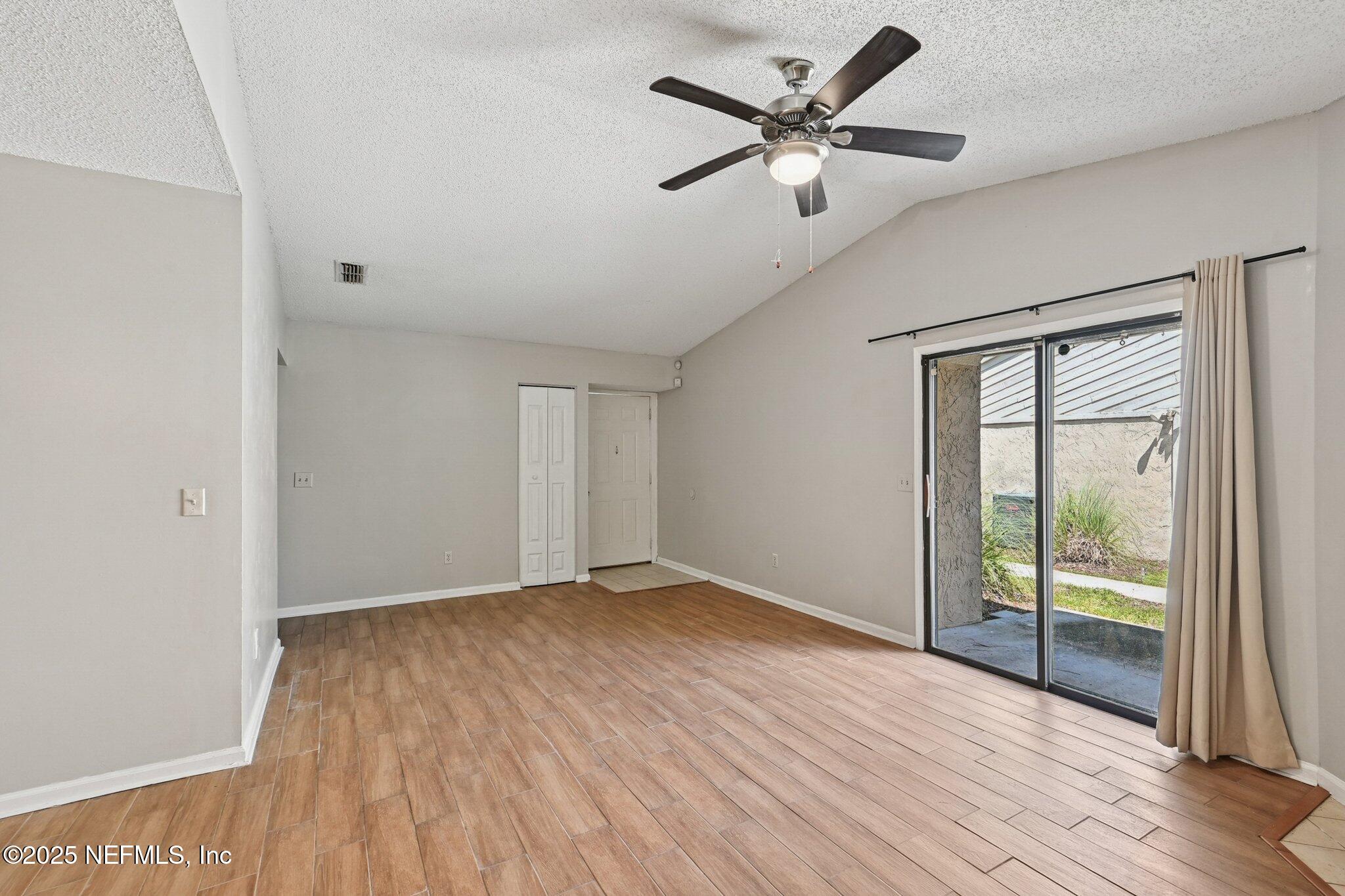 3801 Crown Point Road, Unit 1174 Jacksonville, FL 32257 - Photo 3 of 17 an empty room with wooden floor and windows