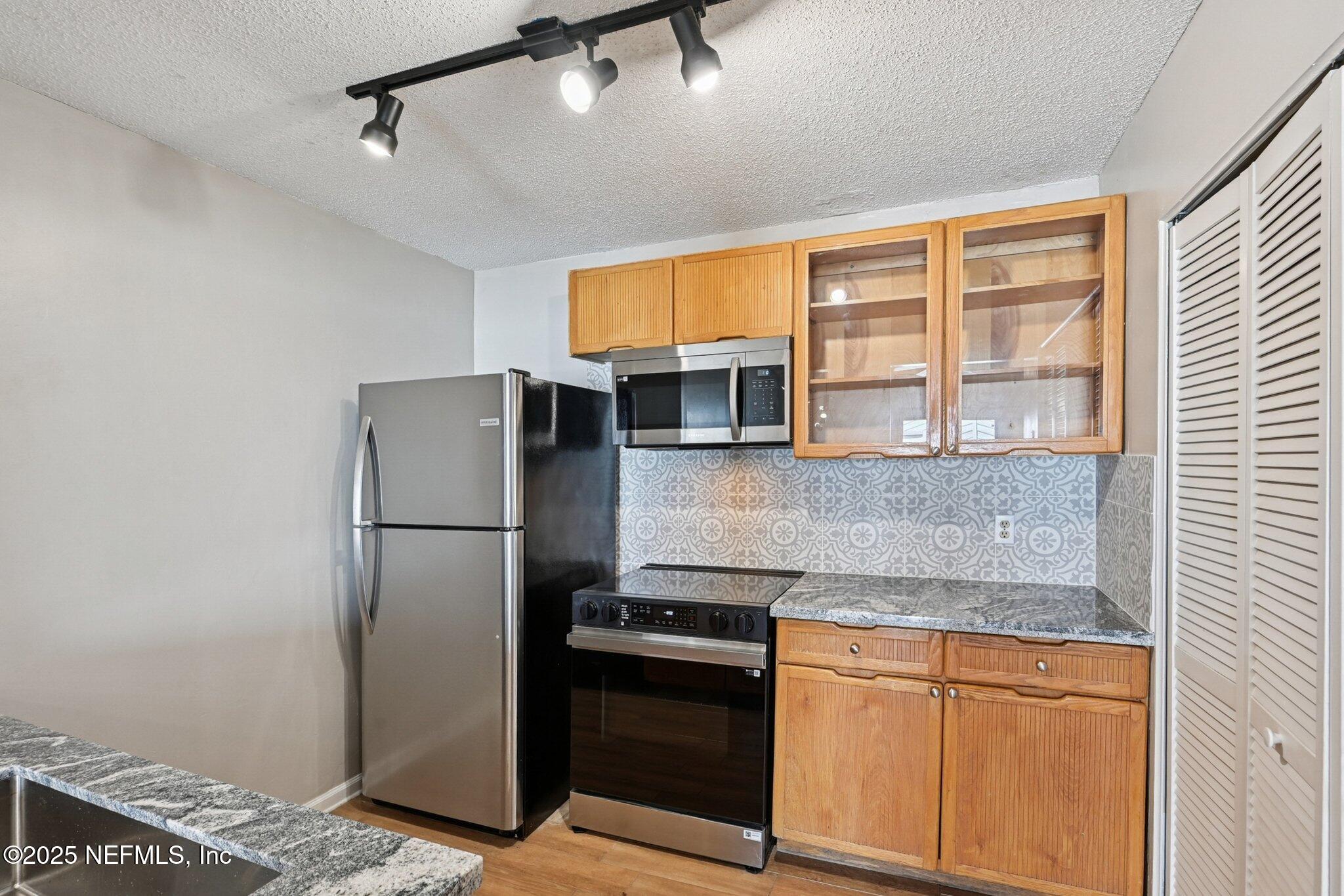 3801 Crown Point Road, Unit 1174 Jacksonville, FL 32257 - Photo 5 of 17 a kitchen with stainless steel appliances granite countertop a refrigerator and a stove