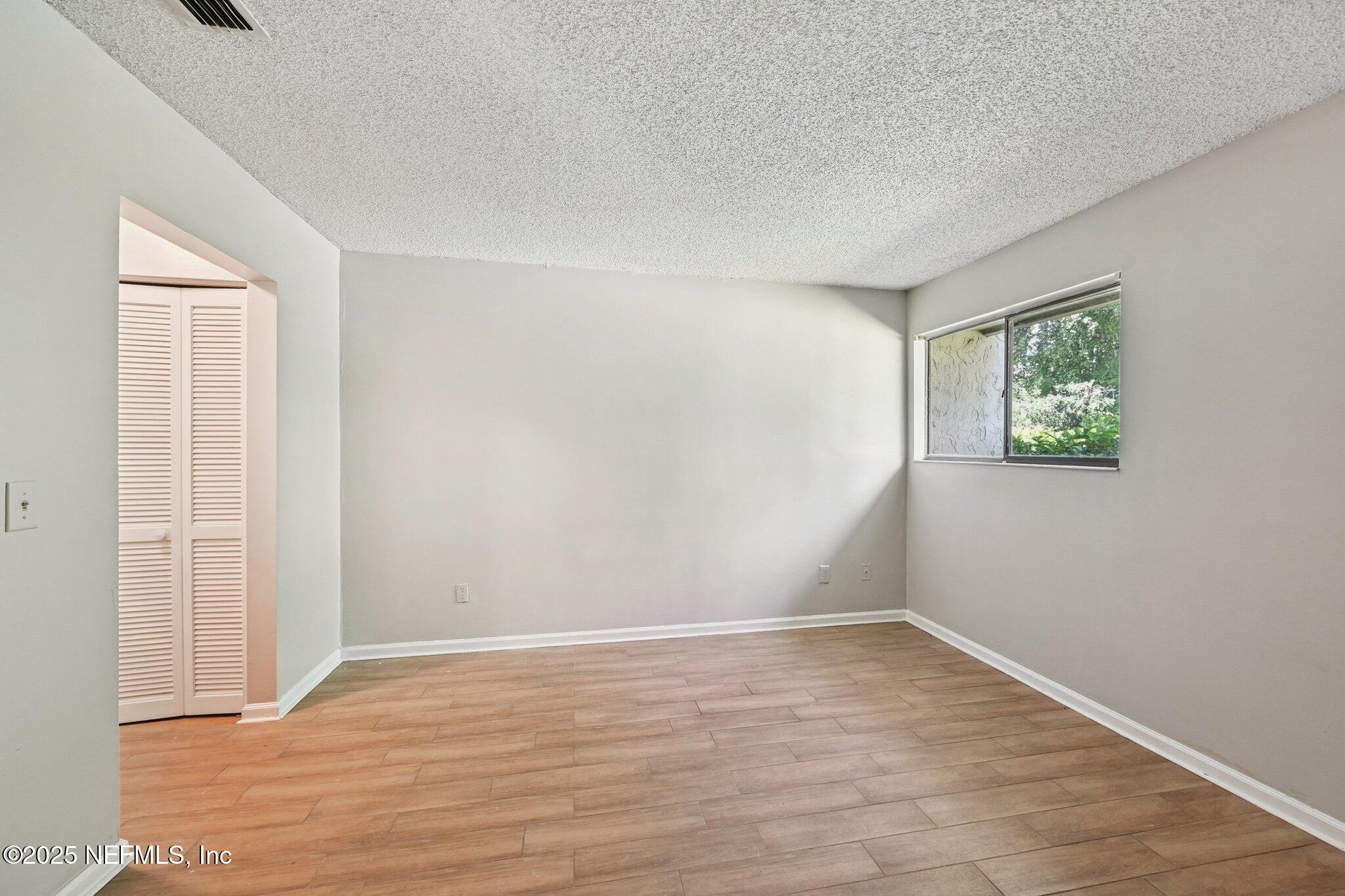 3801 Crown Point Road, Unit 1174 Jacksonville, FL 32257 - Photo 10 of 17 a view of an empty room with wooden floor and a window