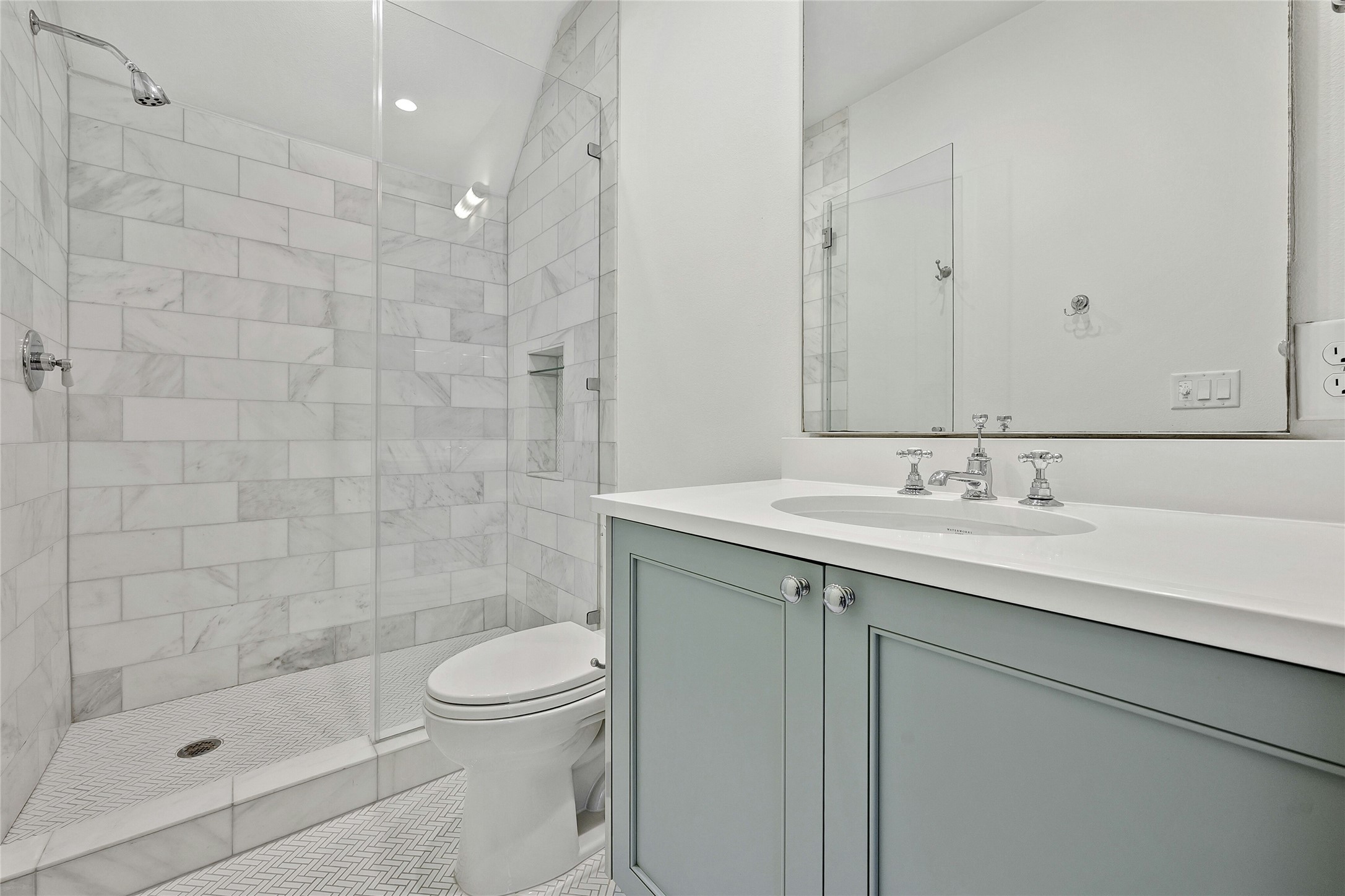 2518 Sutherland Street Austin, TX 78746 - Photo 26 of 30 A well-appointed bath features a tiled shower with a sleek glass enclosure and a vanity with ample counter space.