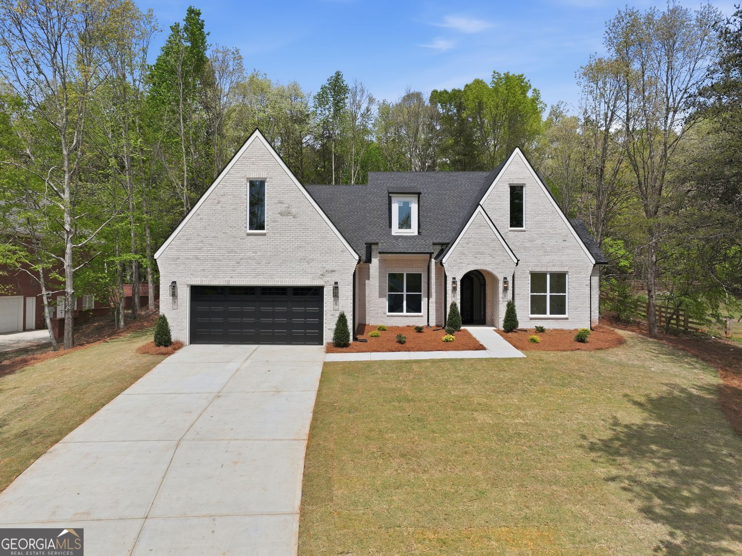 a front view of a house with yard and trees