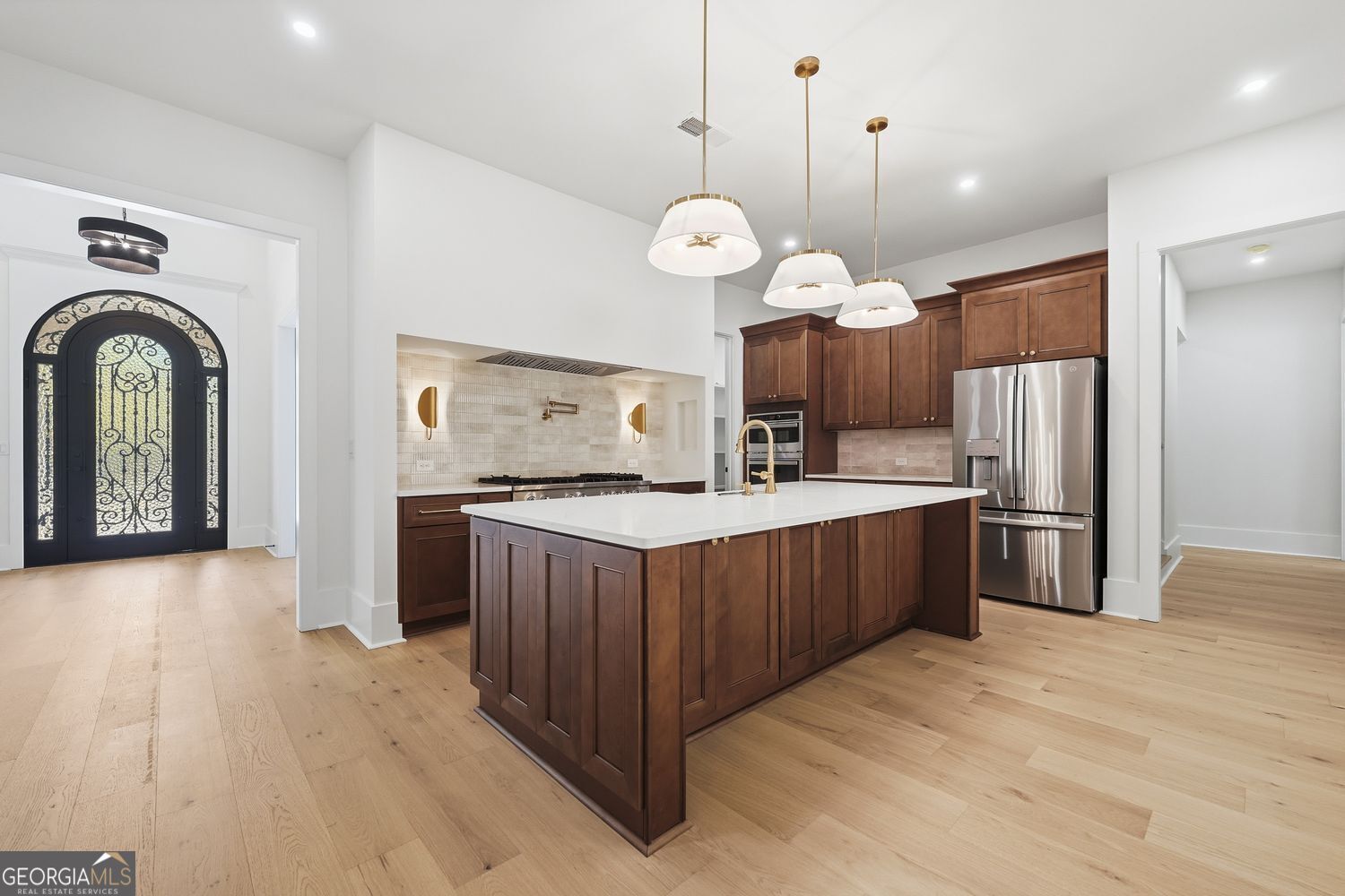 6625 Windvane Point Clermont, GA 30527 - Photo 13 of 45 a large kitchen with stainless steel appliances granite countertop a stove a refrigerator a oven a large island with wooden floor and cabinets