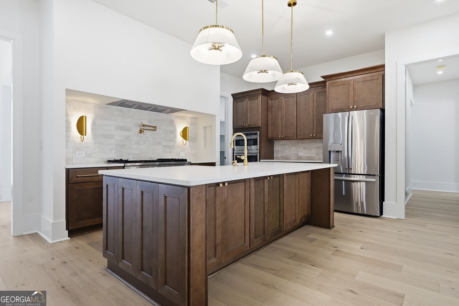 6625 Windvane Point Clermont, GA 30527 - Photo 38 of 45 a kitchen with stainless steel appliances granite countertop a refrigerator a sink dishwasher a kitchen island a stove and a wooden floor