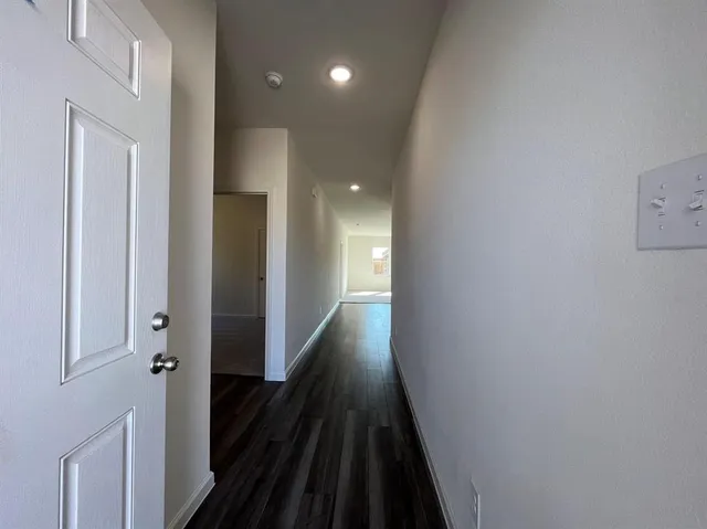 a view of a hallway with wooden floor