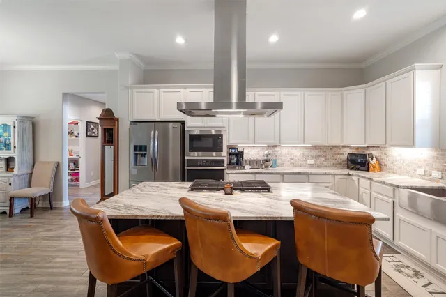 a kitchen with stainless steel appliances kitchen island granite countertop a kitchen island a table and chairs