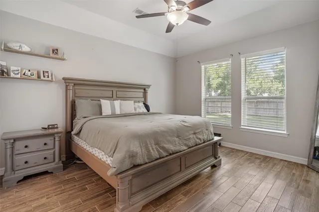 a bed sitting in a bedroom next to a window with a tv on a dresser