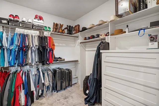 a view of walk in closet with clothes and shoes