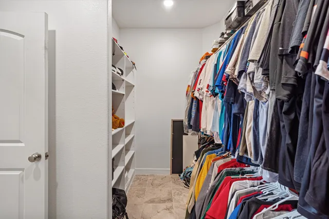 a view of walk in closet with clothes
