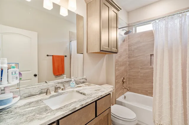 a bathroom with a granite countertop sink toilet and shower