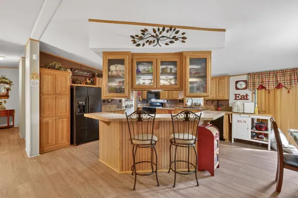 a dining hall with stainless steel appliances granite countertop a stove and a refrigerator
