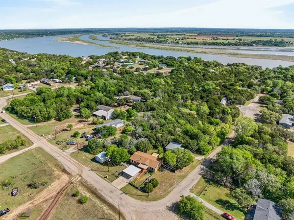 an aerial view of residential houses with outdoor space and trees