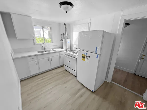 a kitchen with sink cabinets and white appliances