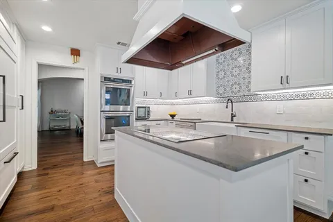a kitchen with stainless steel appliances granite countertop a sink a stove and a refrigerator