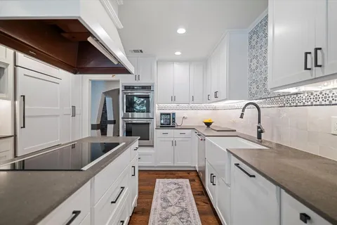 a kitchen with a sink stainless steel appliances and cabinets