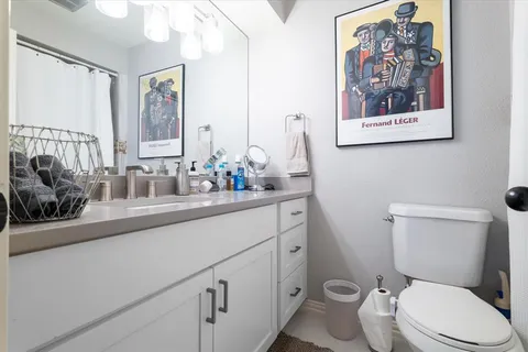 a bathroom with a toilet a sink and mirror