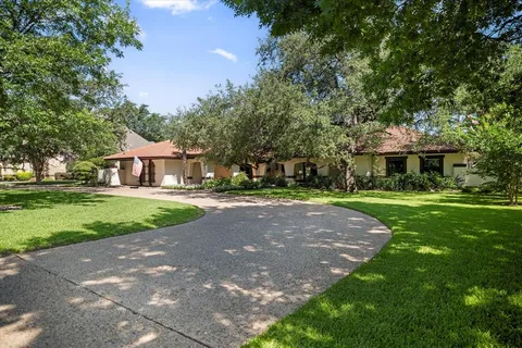 a front view of a house with yard and green space