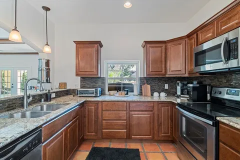 a kitchen with stainless steel appliances granite countertop a sink stove and microwave