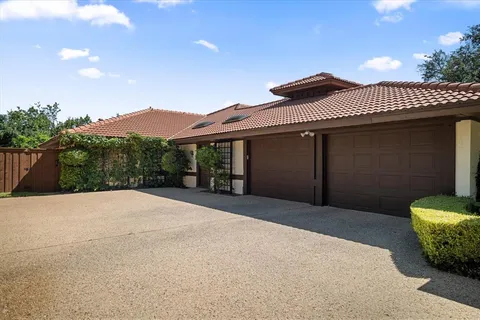 a front view of a house with a yard and mountain view