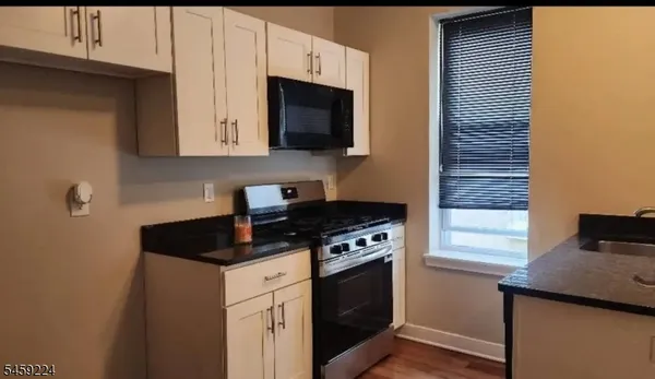 a kitchen with stainless steel appliances granite countertop a stove and a microwave