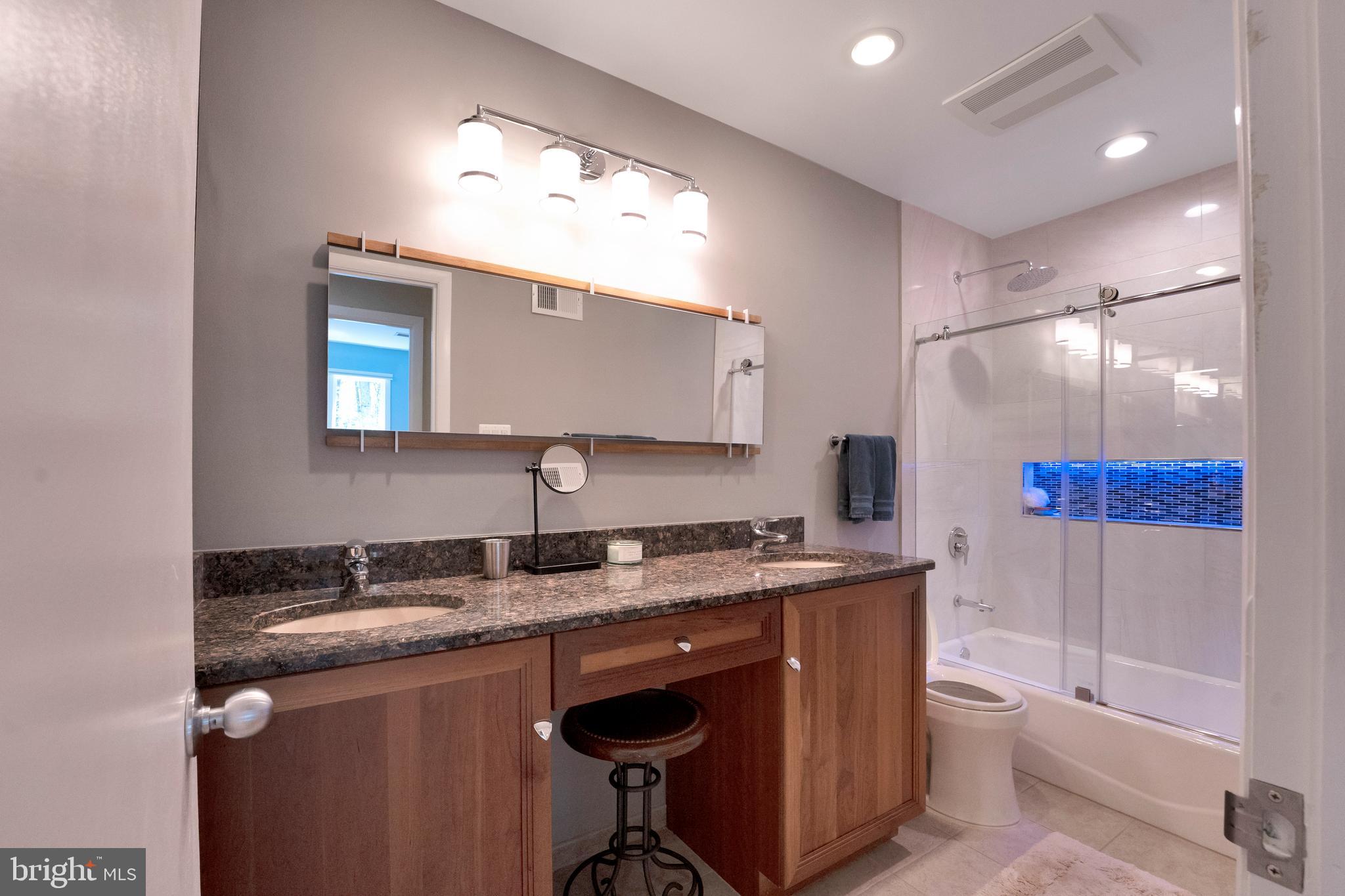 3214 Foxvale Drive Oakton, VA 22124 - Photo 33 of 56 a bathroom with a granite countertop sink a toilet a mirror and shower