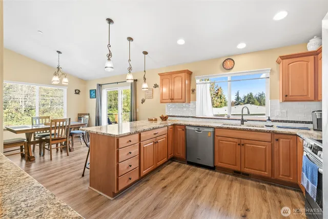 a kitchen with stainless steel appliances granite countertop wooden cabinets a sink and a stove