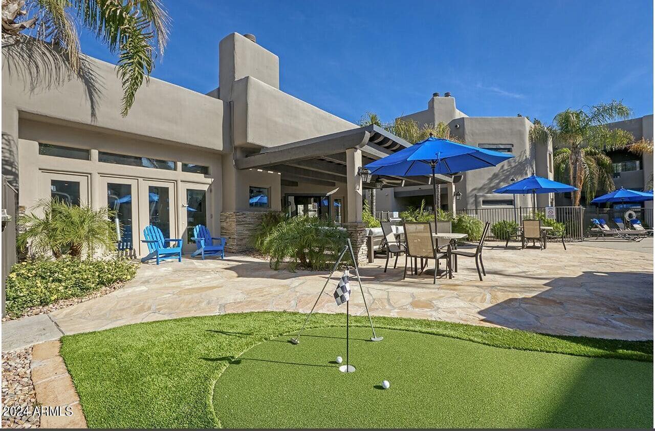9259 East Raintree Drive, Unit 2 Scottsdale, AZ 85260 - Photo 12 of 13 a view of a patio with a table and chairs under an umbrella