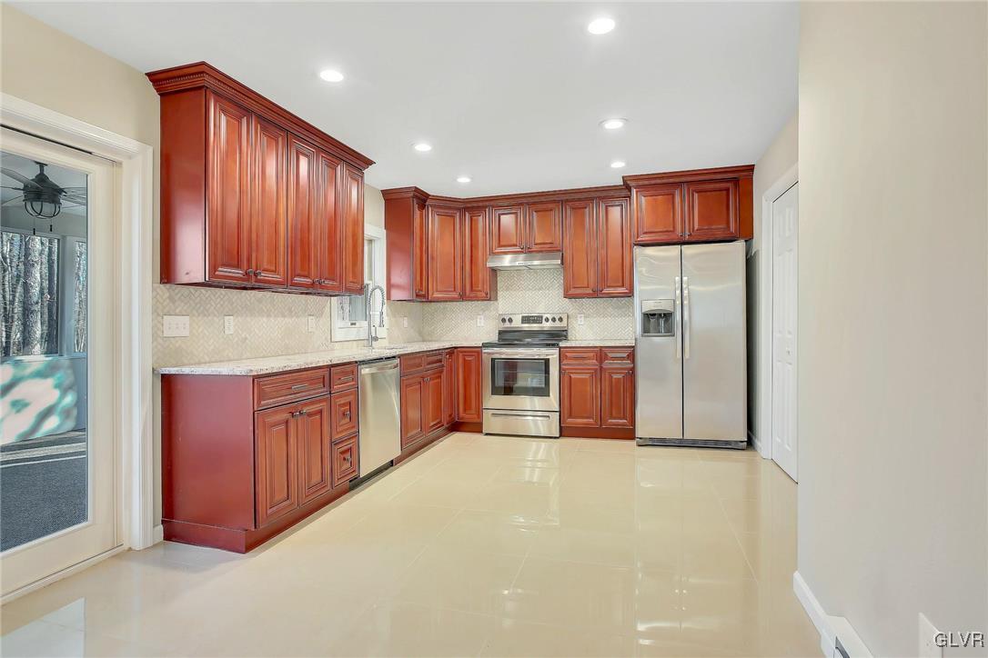 111 Brewster Way East Stroudsburg, PA 18301 - Photo 4 of 30 a kitchen with stainless steel appliances granite countertop a stove refrigerator a sink and dishwasher with wooden cabinets