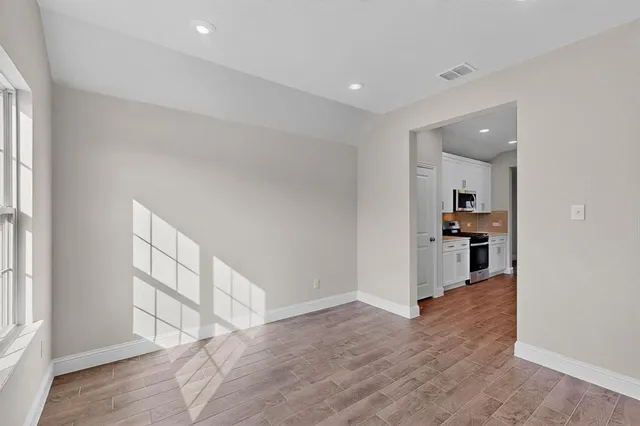 wooden floor in an empty room with a kitchen