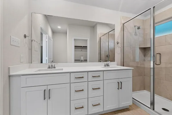 a bathroom with double sink and a mirror