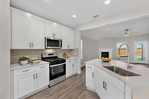 a kitchen with granite countertop white cabinets white stainless steel appliances and sink