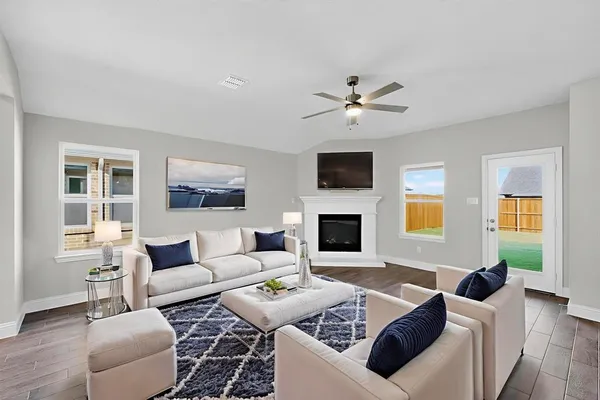 a living room with furniture a fireplace and a flat screen tv