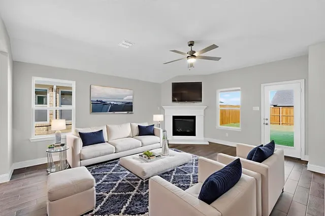 a living room with furniture a fireplace and a flat screen tv