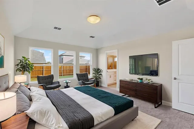 a bedroom with a bed and large windows