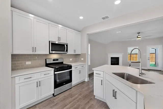 a kitchen with granite countertop white cabinets and white appliances