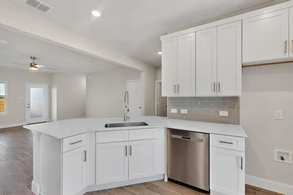 a kitchen with white cabinets and sink