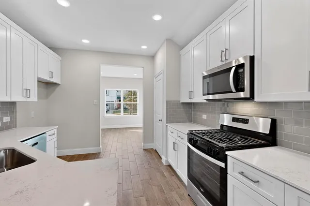a kitchen with stainless steel appliances granite countertop a stove and a microwave