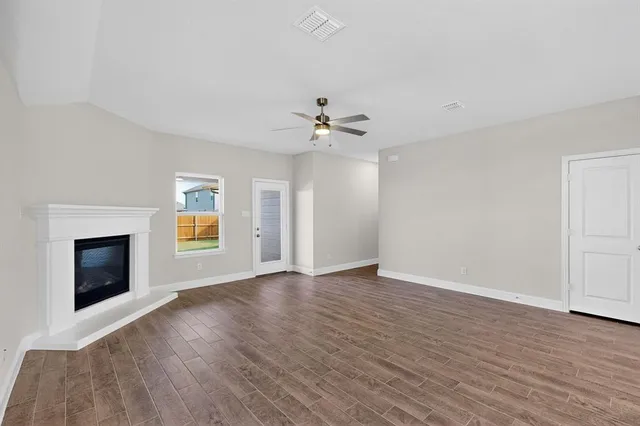 an empty room with windows and fireplace