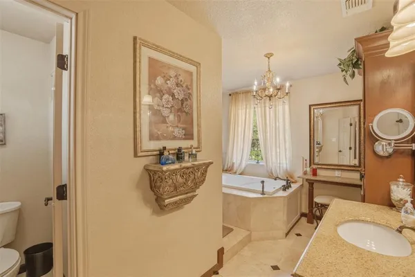 a spacious bathroom with a granite countertop sink and a mirror