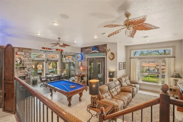 a living room with furniture a chandelier and a floor to ceiling window