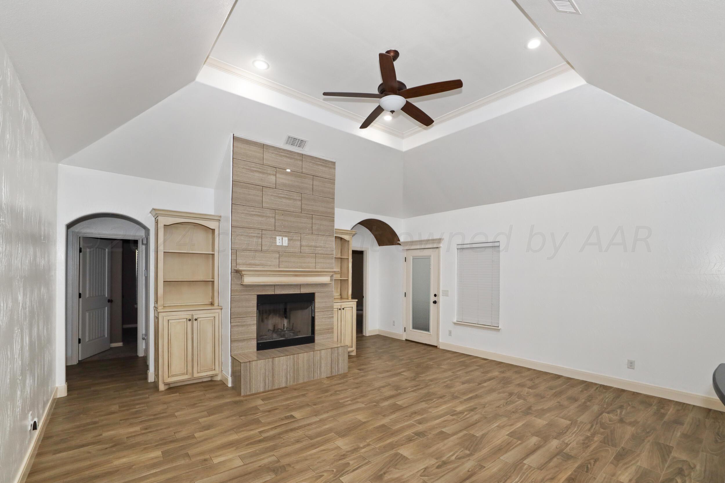 7303 Rochester Drive Amarillo, TX 79118 - Photo 11 of 38 a view of a livingroom with a fireplace and ceiling fan