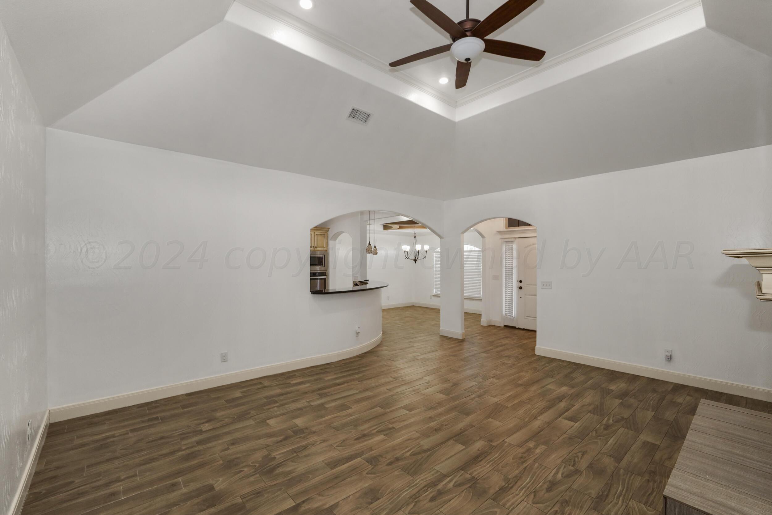7303 Rochester Drive Amarillo, TX 79118 - Photo 13 of 38 an empty room with a ceiling fan and wooden floor