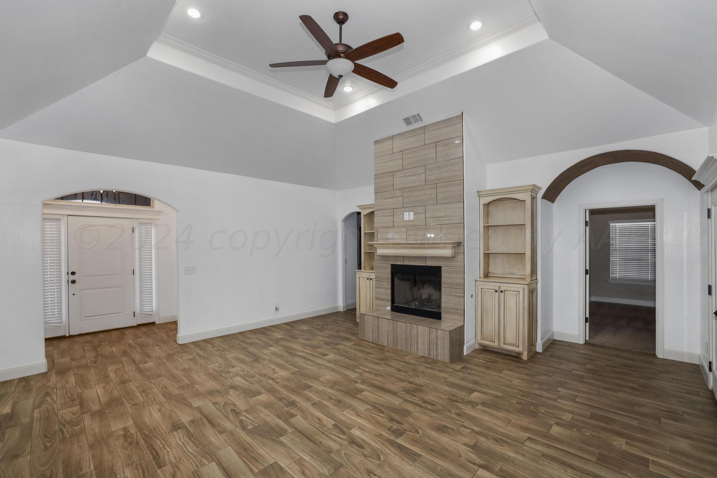 7303 Rochester Drive Amarillo, TX 79118 - Photo 14 of 38 a view of empty room with wooden floor and fireplace