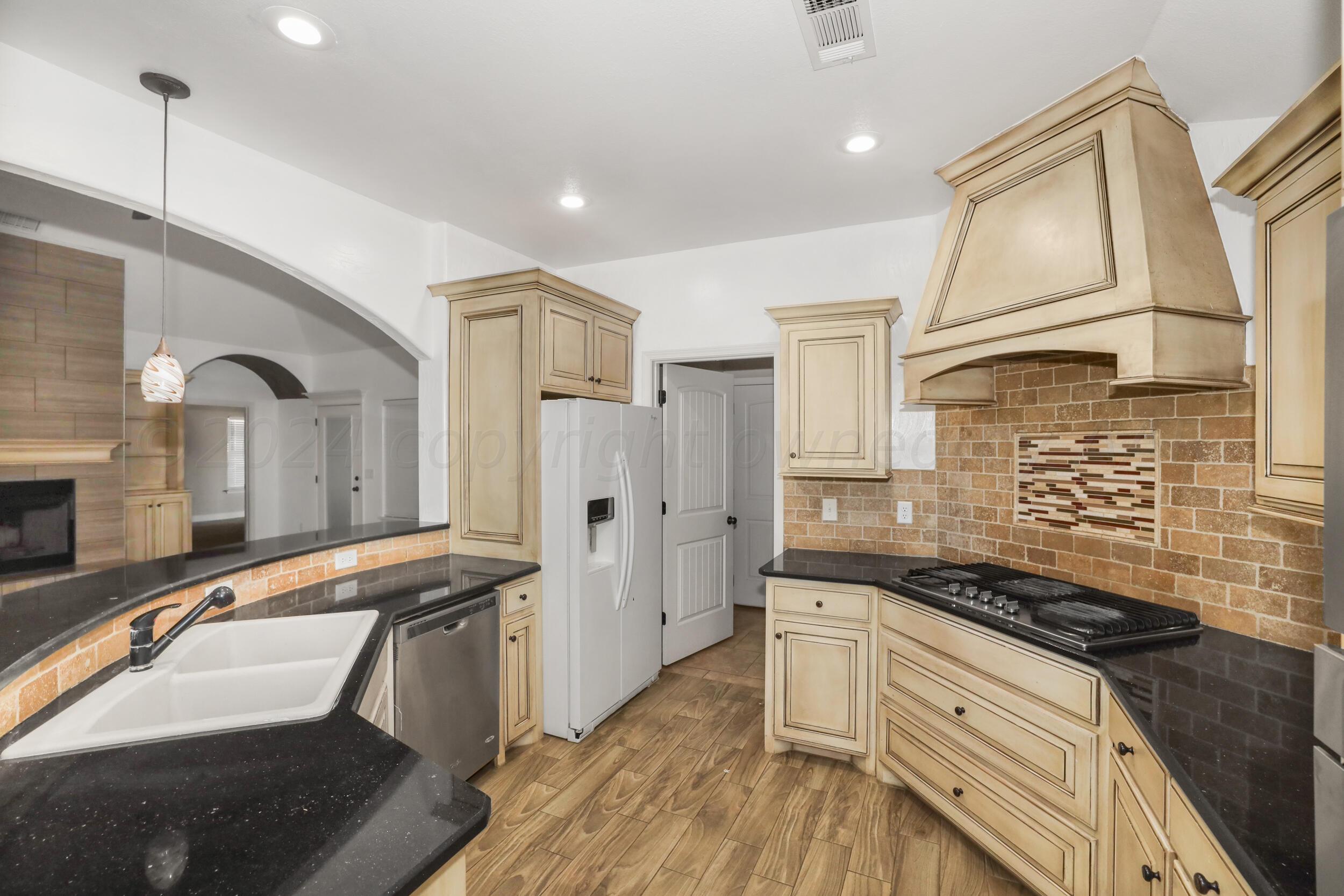 7303 Rochester Drive Amarillo, TX 79118 - Photo 15 of 38 a kitchen with granite countertop a sink stove and refrigerator