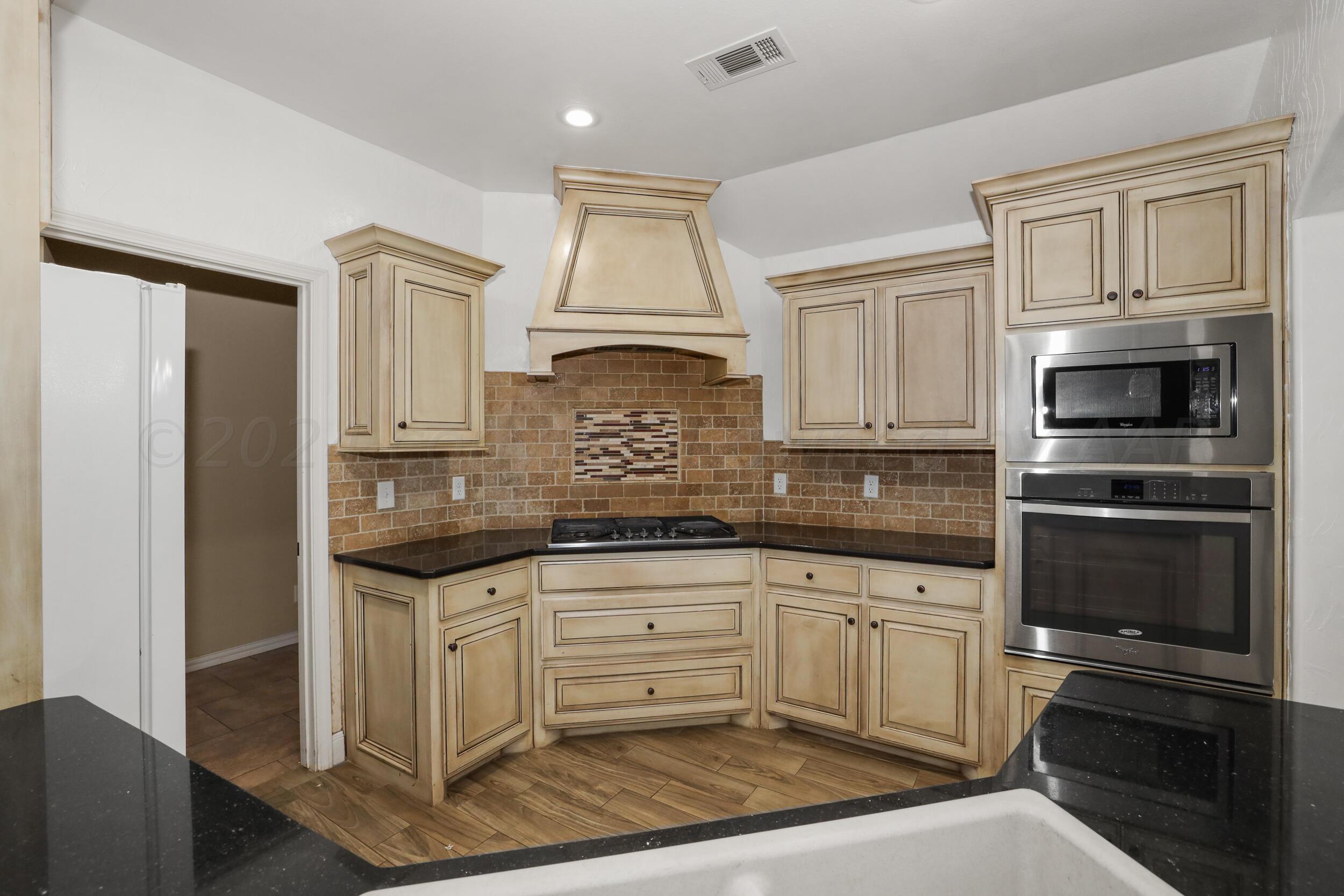 7303 Rochester Drive Amarillo, TX 79118 - Photo 10 of 38 a kitchen with granite countertop a sink stainless steel appliances and cabinets